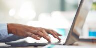 hands typing on a laptop keyboard