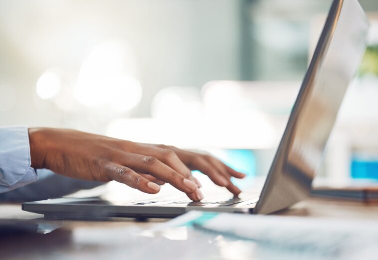 hands typing on a laptop keyboard