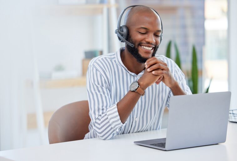 smiling man with headset using a laptop