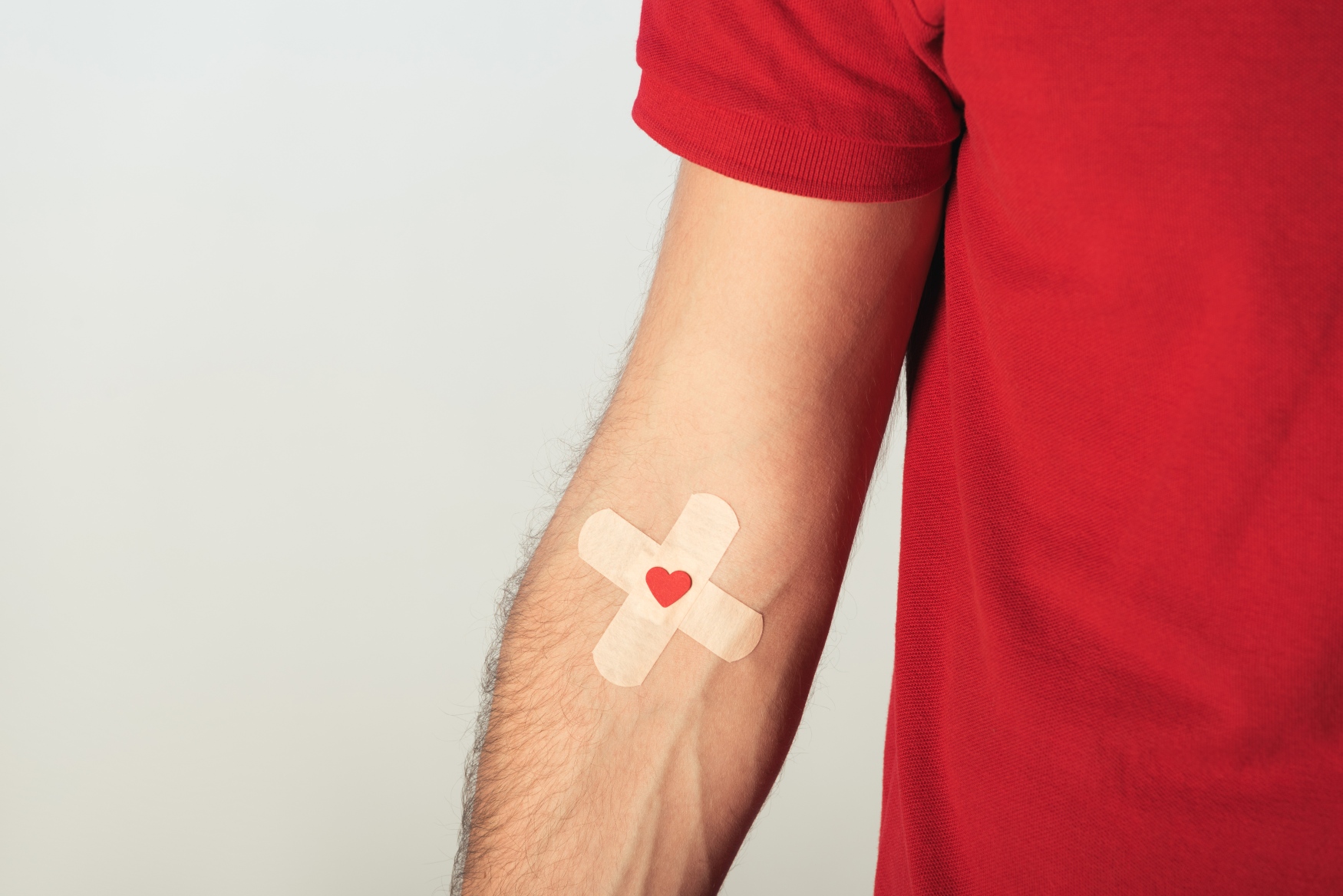 man's arm with a double plaster and a heart on his veins