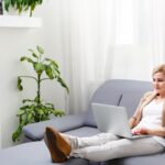 woman working on a laptop while sitting on a couch