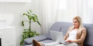 woman working on a laptop while sitting on a couch