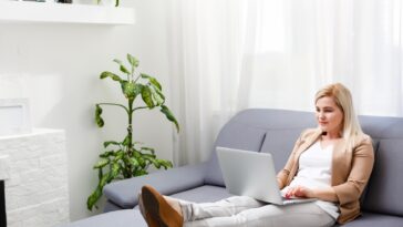 woman working on a laptop while sitting on a couch