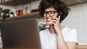 woman talking on the phone looking at a computer