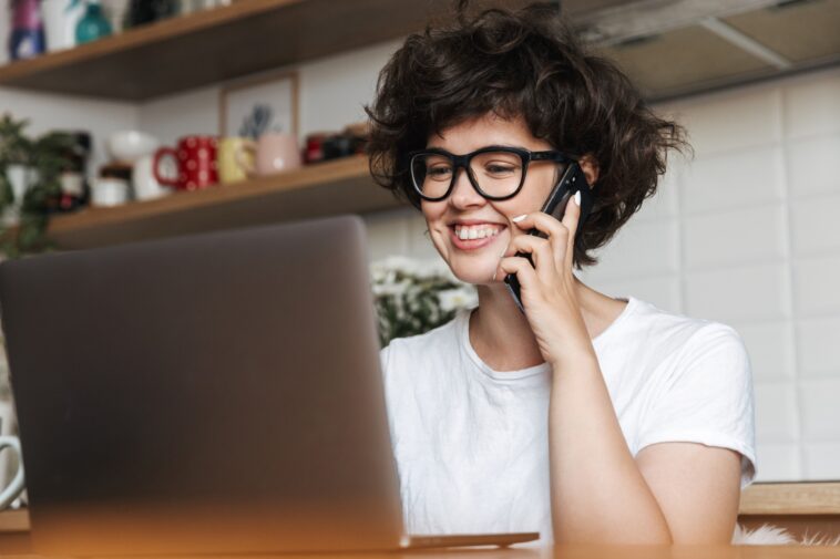 woman talking on the phone looking at a computer