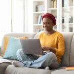 woman sitting on a couch with a laptop in her lap