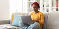 woman sitting on a couch with a laptop in her lap