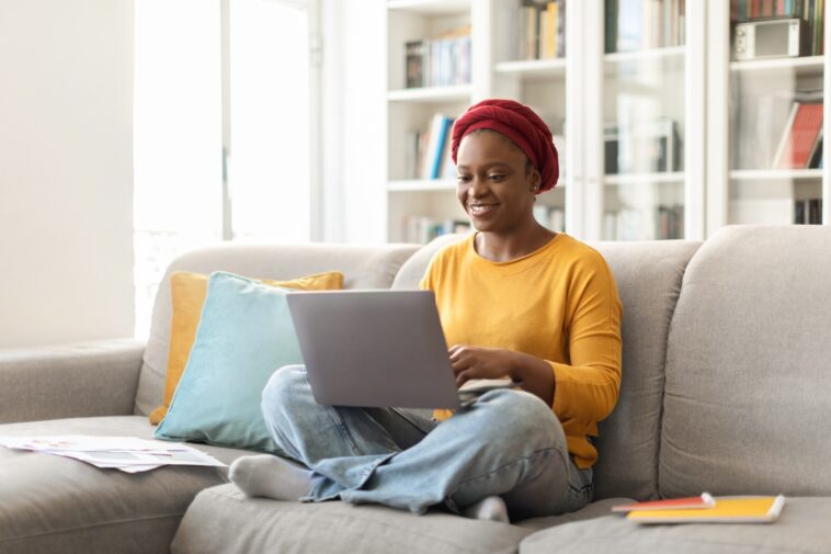 woman sitting on a couch with a laptop in her lap