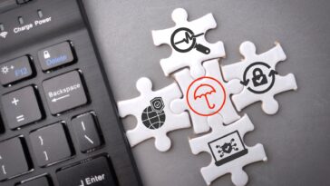 puzzle with cybersecurity icons next to a keyboard