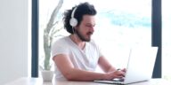 man with headphones using a laptop from home