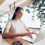 woman sitting at a desk working on a laptop