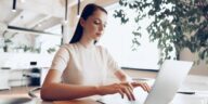 woman sitting at a desk working on a laptop