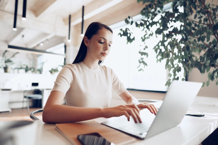 woman sitting at a desk working on a laptop