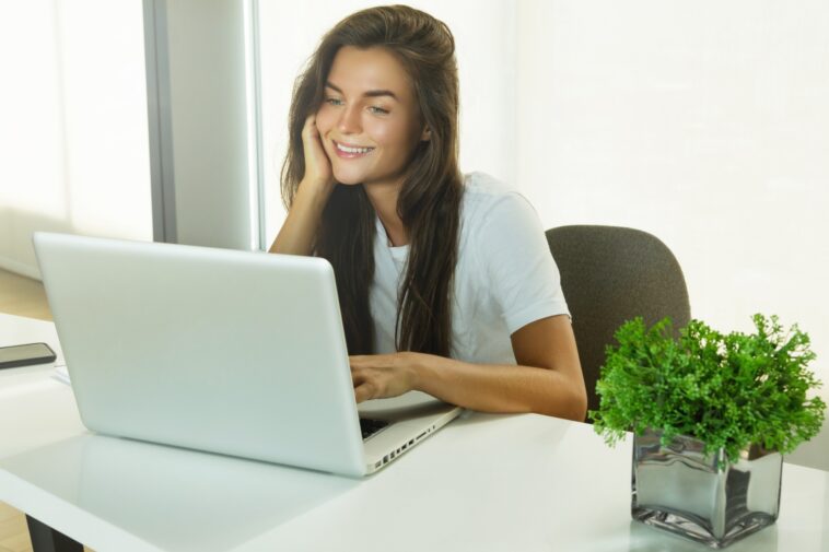 woman sitting at a desk using a laptop