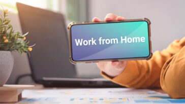 person holding a smartphone with a work from home message on the screen