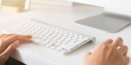 closeup of hands using a computer keyboard and mouse