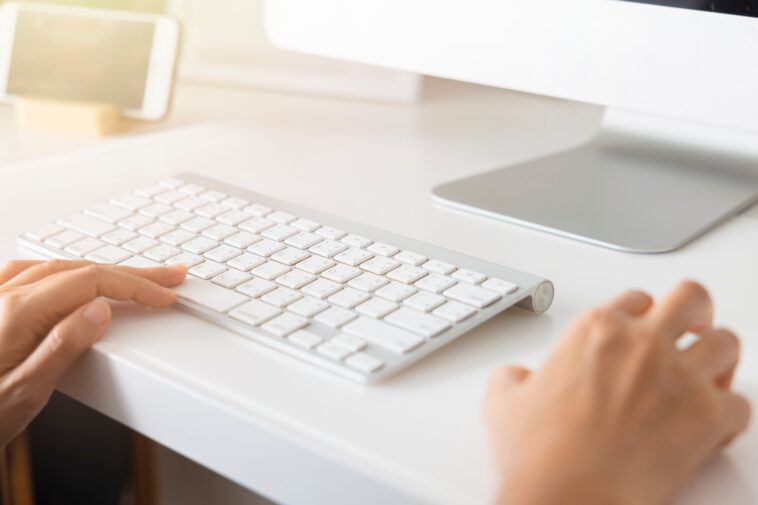 closeup of hands using a computer keyboard and mouse