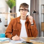 man using a headset and a laptop working from home