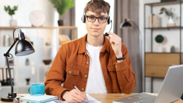 man using a headset and a laptop working from home