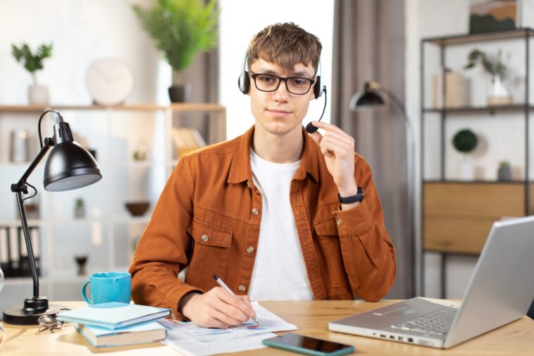 man using a headset and a laptop working from home