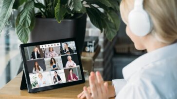 woman with headset on a video call with multiple people