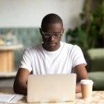 man sitting at a desk working on a laptop