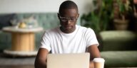 man sitting at a desk working on a laptop