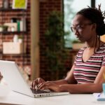 woman working on a laptop from a home office