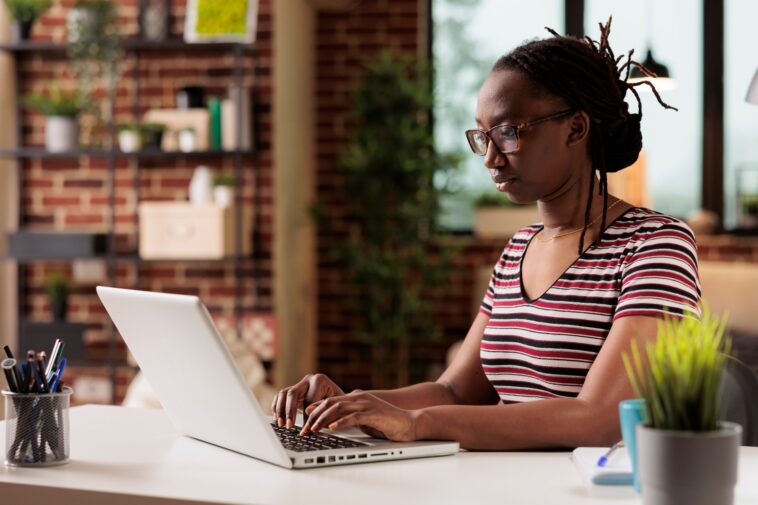 woman working on a laptop from a home office