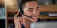 smiling man with a headset working as an agent from home