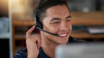 smiling man with a headset working as an agent from home