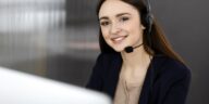 smiling girl with a headset working on a computer