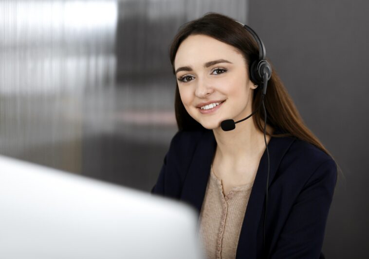 smiling girl with a headset working on a computer