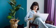 woman sitting in a chair at home with a laptop in her lap