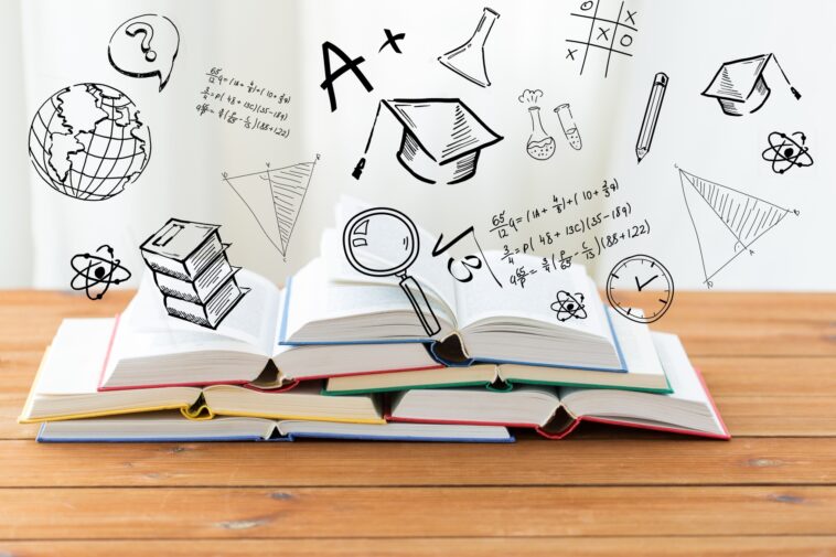 books on a wooden table with 3D education icons above them