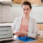 woman next to a laptop screen that says English language