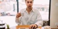 man working on a laptop drinking coffee