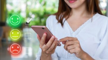 woman giving a rating on a smartphone with smiley icons