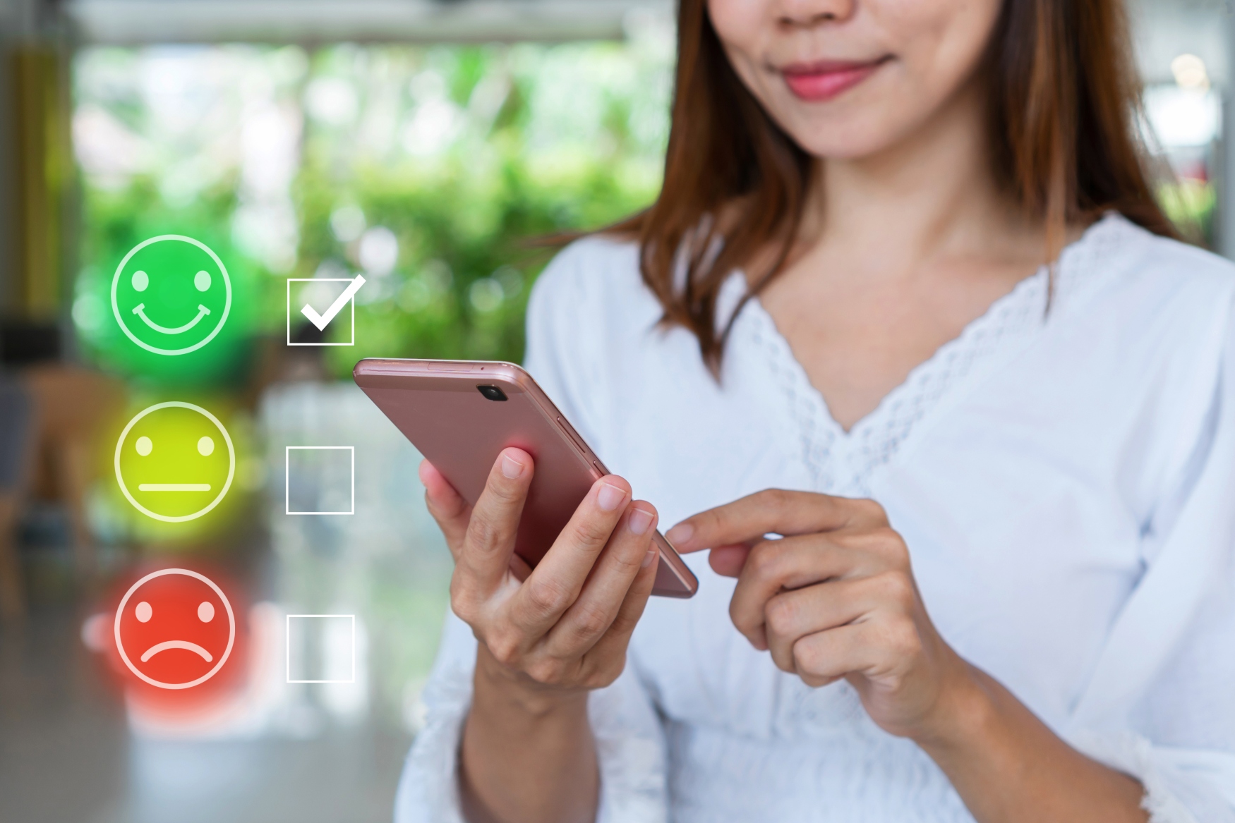 woman giving a rating on a smartphone with smiley icons