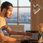 man working on a laptop at an office desk