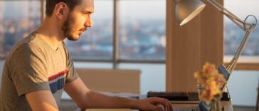 man working on a laptop at an office desk