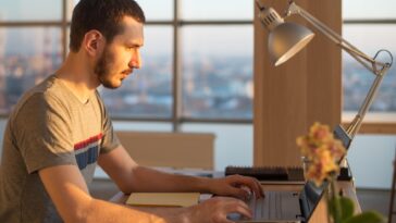 man working on a laptop at an office desk