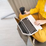 closeup of person using a laptop and drinking coffee