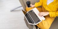 closeup of person using a laptop and drinking coffee