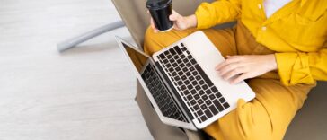 closeup of person using a laptop and drinking coffee