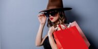 woman with a hat and sunglasses holding shopping bags