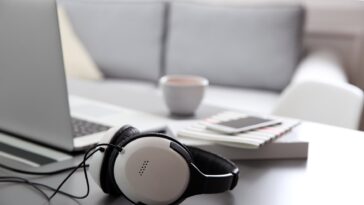 headphones next to a laptop on a table in a living room