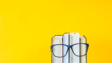 a stack of books with glasses