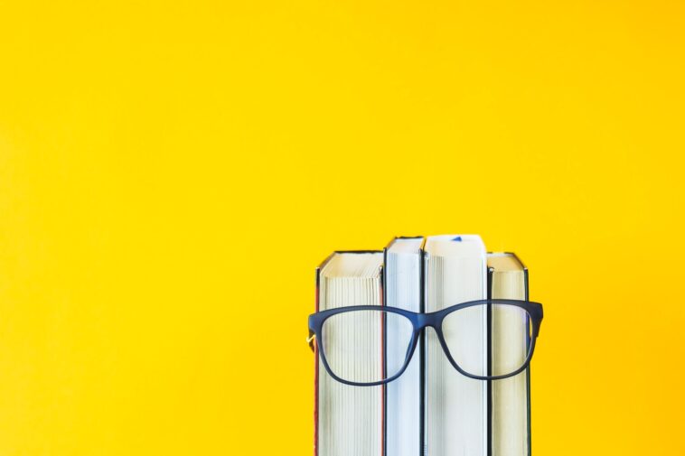 a stack of books with glasses