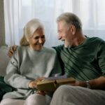 two grandparents holding a book sitting on a sofa